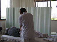 治療実習風景。利用者が指導員をベッド上で施術をしています。