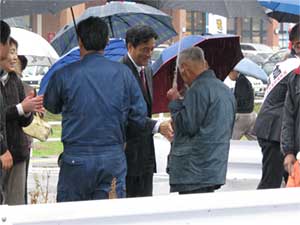 雨の中、支持者と握手を交わす岡田・民主党副代表