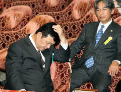 衆院テロ防止特別委の証人喚問で、補佐人の弁護士(右)との協議を深谷委員長に注意され、頭を抱える守屋武昌前防衛事務次官=29日、中日新聞