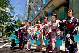 打ち水をする、浴衣姿の女性たち=9日正午すぎ、大阪市中央区で