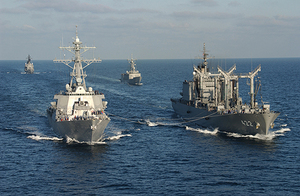 相手国艦艇に給油中の補給艦「とわだ」(右)と、後方は警戒に当たる護衛艦