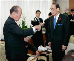 教科書検定に関する要望書を渡海文科相(右)に手渡す沖縄県の仲井真知事=3日午前、文科省