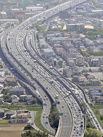 帰省や行楽の車で混雑する中国自動車道下り線(右側)=3日、兵庫県宝塚市〔共同〕