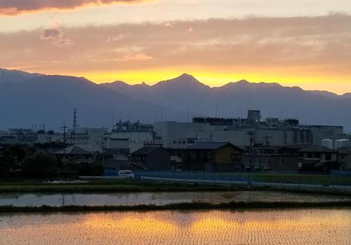 槍ヶ岳の夕日が田に映る